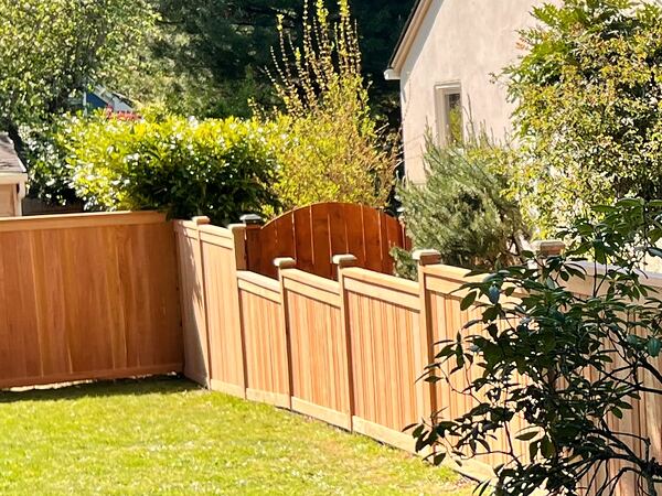 Arched cedar gate in a wood fence