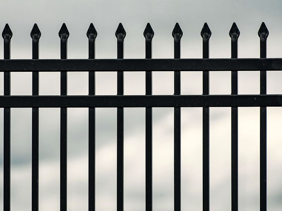 Black metal fence with spear-top pickets