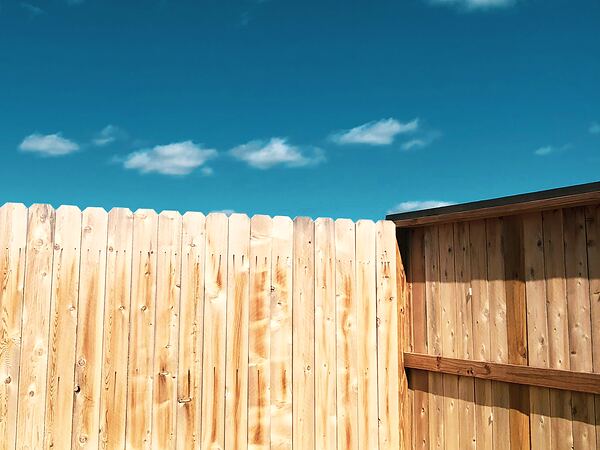 New wood privacy fence under a clear blue sky